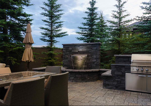 Back yard BBQ, water feature and patio in this landscape design in Aspen, Calgary